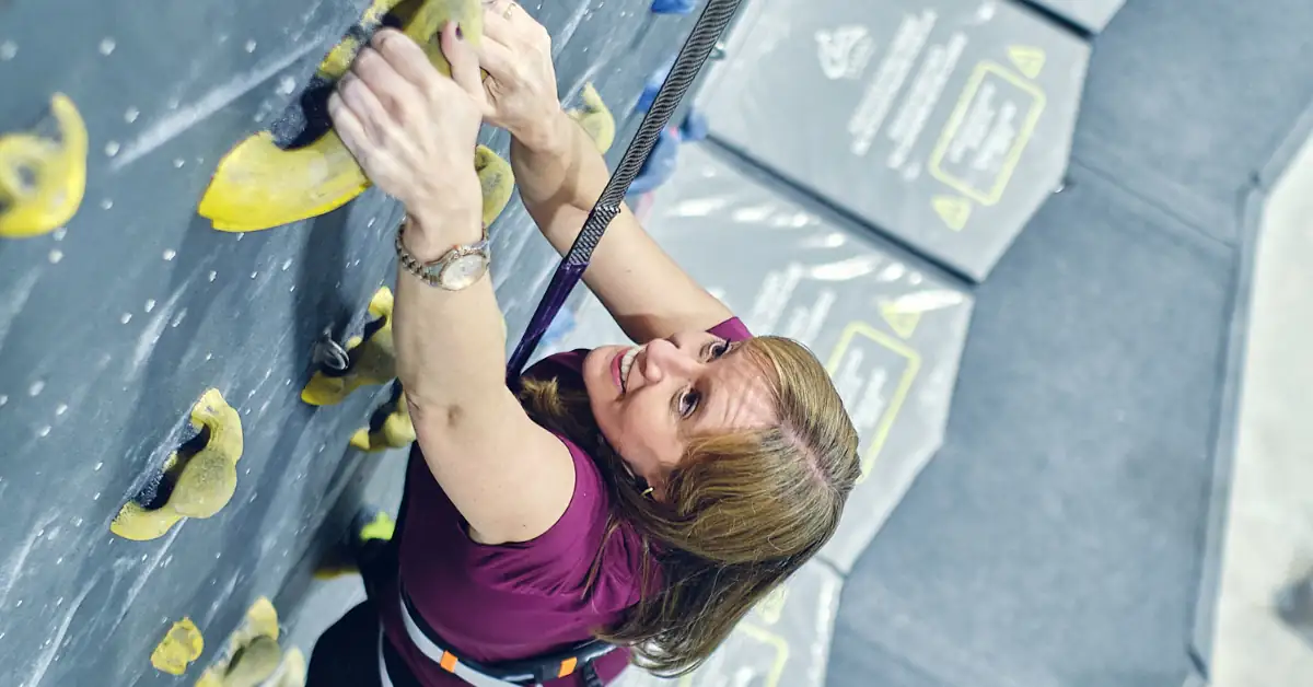 Team building activities for companies in Madrid with a woman overcoming a climbing challenge