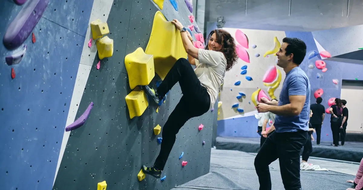 Team building ideas in Madrid for teams with a participant climbing alongside an instructor