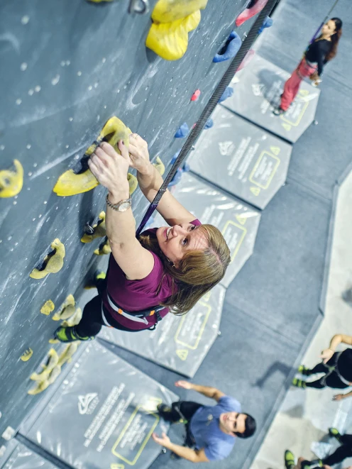 eventos de team building Madrid mujer escalando en rocódromo eventos de team building Madrid mujer escalando en rocódromo