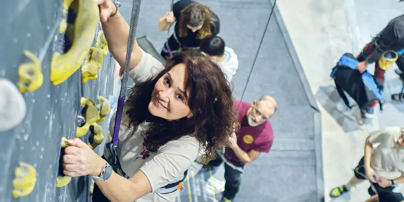 eventos de team building en Madrid mujer escalando en rocódromo