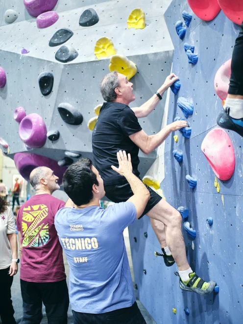 team building en Madrid hombre escalando mientras el equipo acompaña team building en Madrid hombre escalando mientras el equipo acompaña